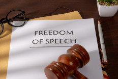 A document that reads "Freedom of Speech" is seen on a desk under a gavel in this undated illustration.