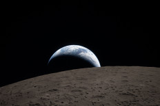 This handout picture released on April 7, 2026, by NASA shows Earth as it dips beyond the lunar horizon, also known as &ldquo;Earthset,&ldquo; as seen from the Orion spacecraft on April 6, 2026. The Artemis II astronauts wrapped up their lunar flyby as they continue their journey back to Earth on Tuesday, bringing with them rich celestial observations including little-known lunar craters, a solar eclipse and meteor strikes that scientists hope will open doors. 