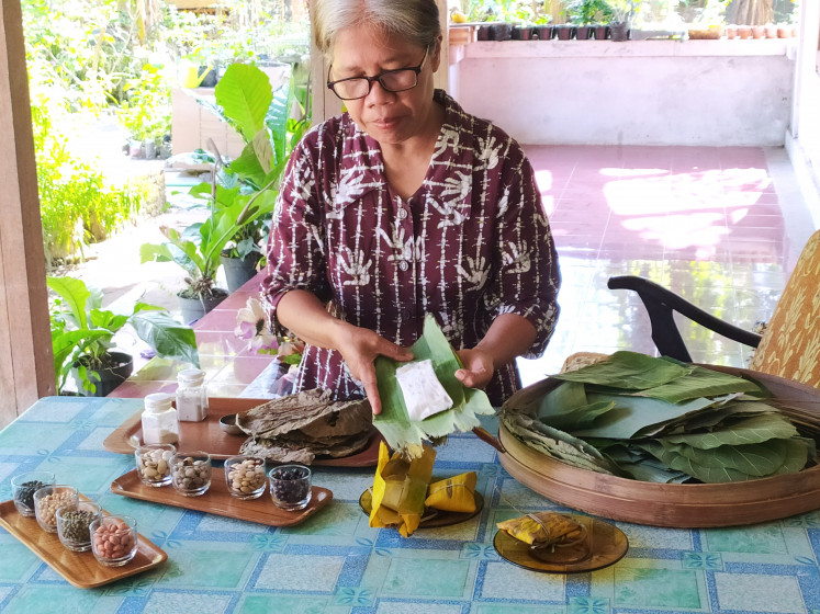 Traditional tempeh-making is an eco-friendly process, using natural starters from plant-based wraps to ferment soybeans before molding them into shape, as seen in this 2021 file photo.