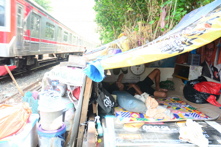 A resident sleeps inside a dwelling located along a railway track in the Senen area of Central Jakarta, Indonesia, on Thursday, April 2, 2026.