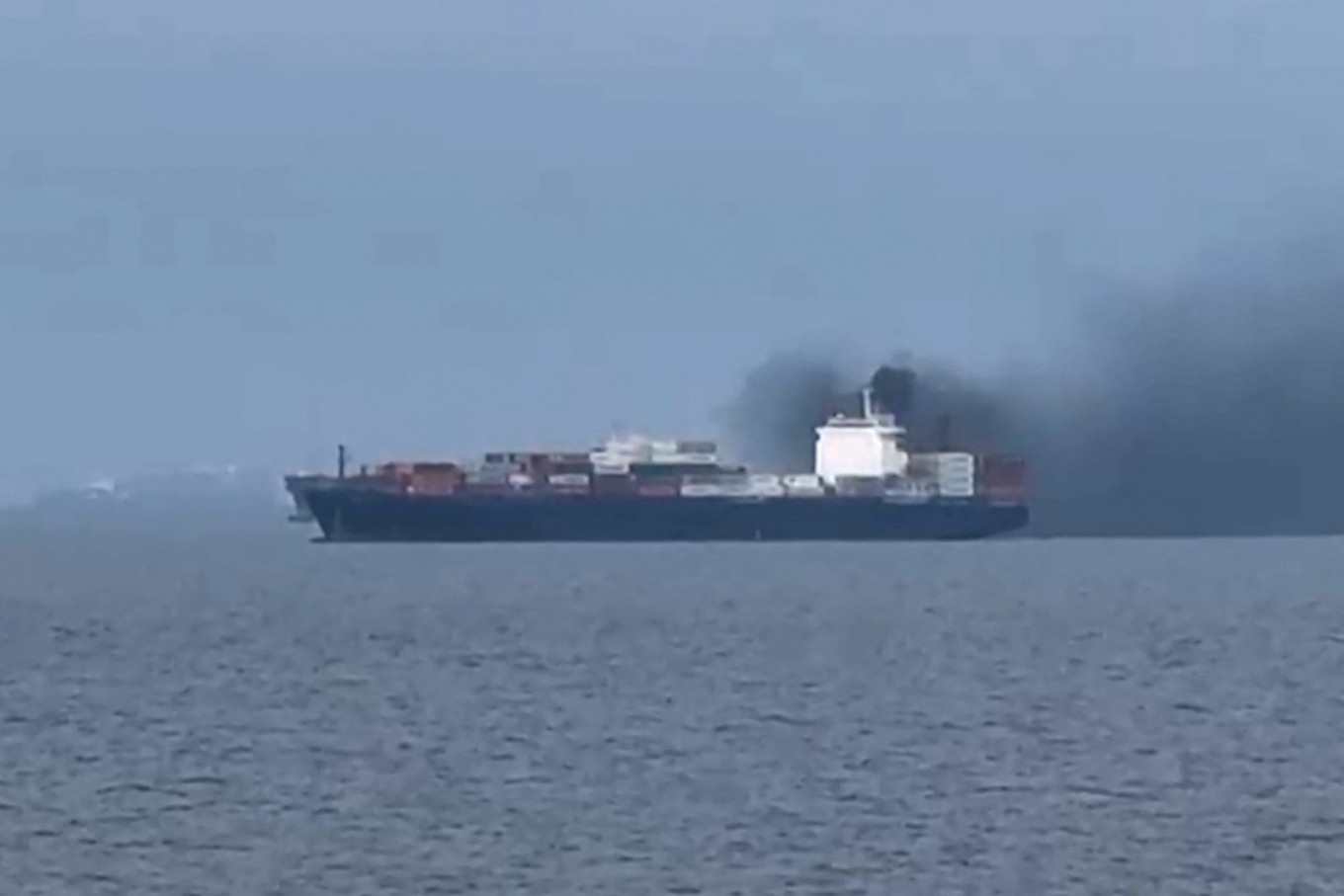 Smoke emerges from the Source Blessing cargo vessel, as filmed by seafarer Wang Shang in the Gulf, north of Dubai on March 12, 2026 and released to AFPTV on March 13.