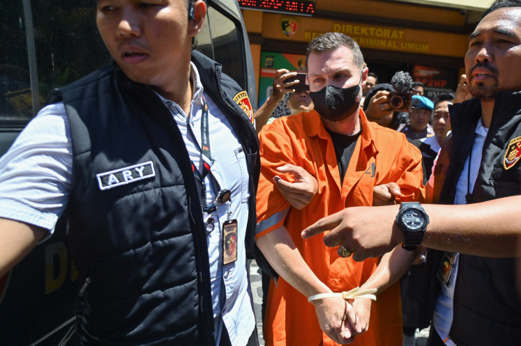 Indonesian police escort Interpol fugitive Steven Lyons (center) on March 31 at the Bali Police Headquarters in Denpasar, Bali. The Scottish-born man is allegedly the leader of a large-scale transnational criminal organization involved in drug trafficking and money laundering. He was arrested at I Gusti Ngurah Rai International Airport on March 28.
