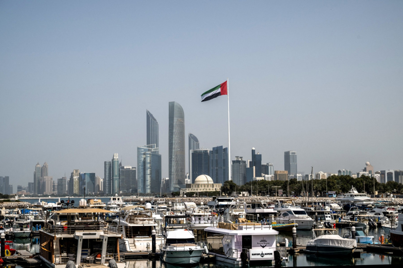 The United Arab Emirates flag flutters against the backdrop of the Abu Dhabi Skyline following a reported Iranian strike on March 1.