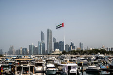 The United Arab Emirates flag flutters against the backdrop of the Abu Dhabi Skyline following a reported Iranian strike on March 1.