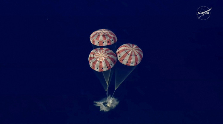 The Artemis II crew capsule splashes down in the Pacific Ocean in this screengrab from a livestream video after the Artemis II crew's flyby of the Moon, April 10, 2026. 