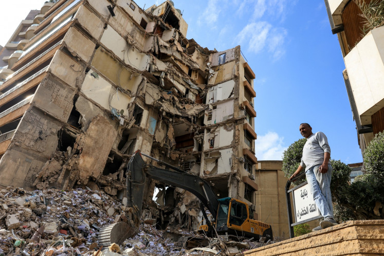 A man stands near a damaged building at the site of an Israeli strike carried out on April 9, 2026 in Tallet El Khayat in Beirut, Lebanon.