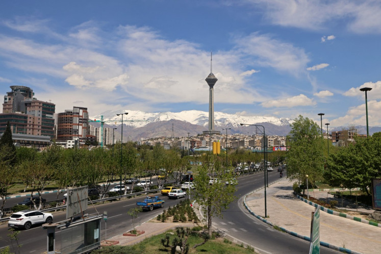 Motorists drive along a busy street past the Milad Tower (center) in Tehran on April 11, 2026. An Iranian government delegation met Pakistan's prime minister on April 11 to discuss the terms of planned &ldquo;make or break&ldquo; negotiations to end the Middle East war with a US party led by Vice President JD Vance.