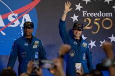 Artemis II Pilot Victor Glover (left) and Commander Reid Wiseman (right) greet the crowd during a press conference on April 11, 2026 at Ellington Field Joint Reserve Base in Houston, Texas. The four astronauts' historic 10-day mission around the moon concluded successfully on Saturday. April 10, 2026.