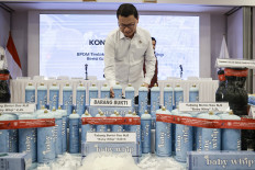 Drug and Food Monitoring Agency (BPOM) head Taruna Ikrar inspects gas canisters for a nitrous oxide product during a press briefing on April 9 at the agency's office in Jakarta. The agency and the police suspected the product was distributed illegally as a recreational drug.