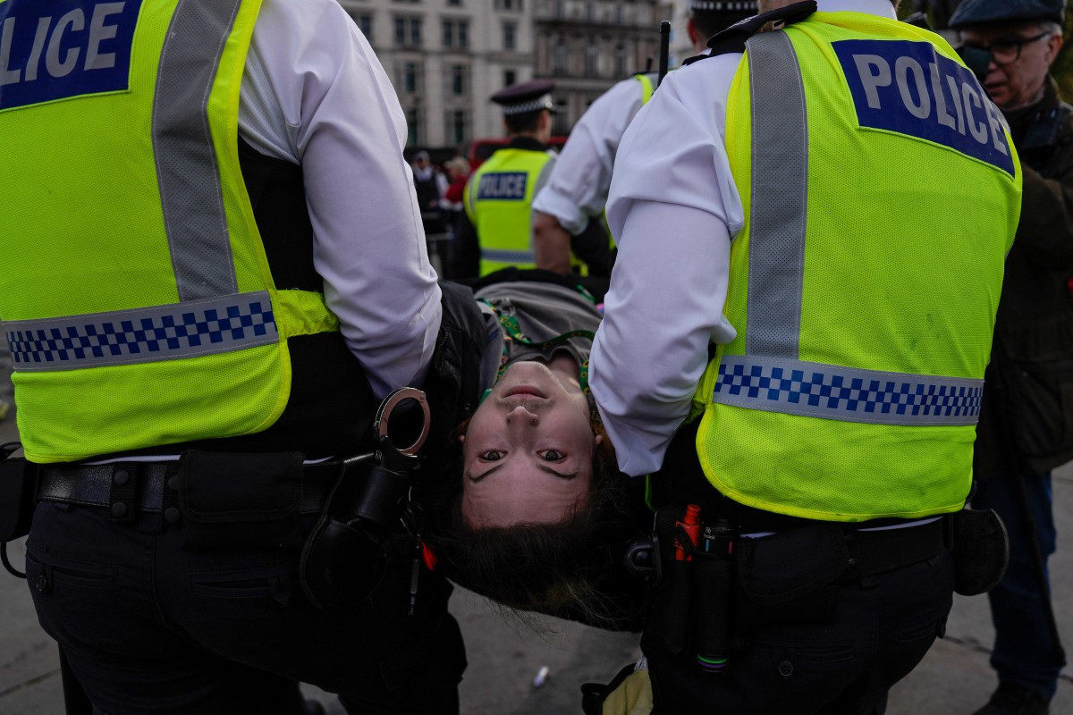 Police carry away a protester as people gather to call for the lifting of the ban on the Palestine Action group during a demonstration in Trafalgar Square in central London on April 11, 2026. Britain's Prime Minister Keir Starmer's Labor government banned Palestine Action as a terrorist organization in 2025, making it a criminal offence to belong to or support the group.