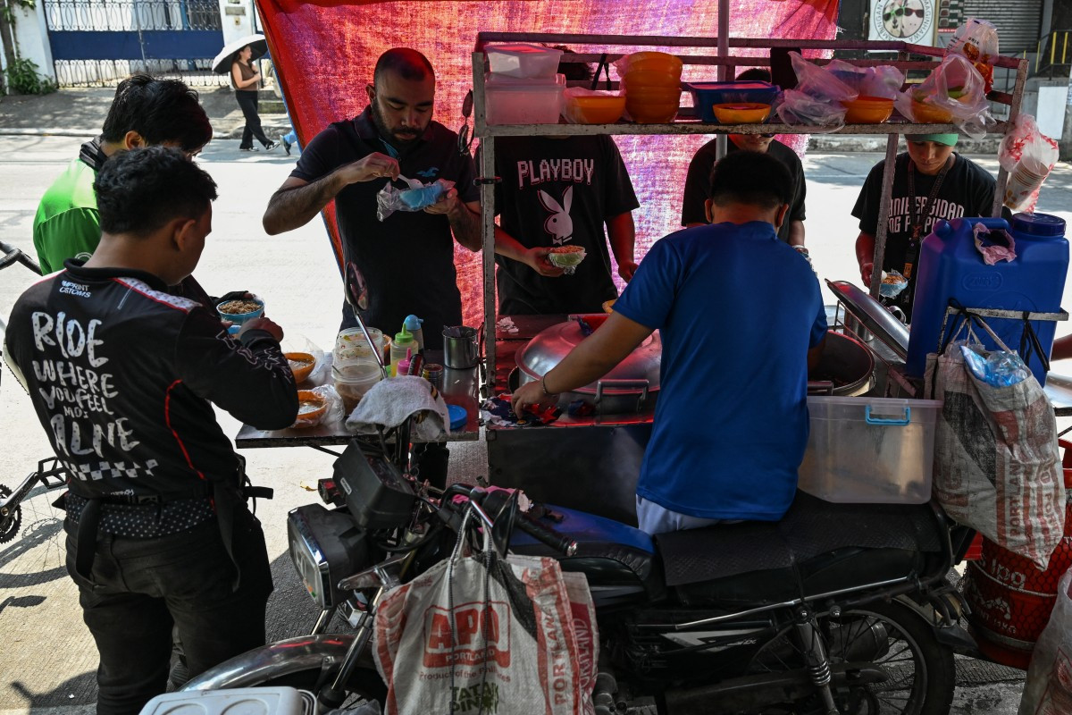 People eat braised beef stew locally known as pares at a stall in Manila on April 7, 2026. While sticker shock at petrol stations has garnered the biggest headlines since the war in the Middle East forced the partial closure of the Strait of Hormuz, the rising price of LPG has hit the import-dependent archipelago's humble street food vendors hard.