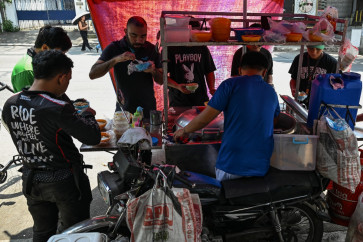 People eat braised beef stew locally known as pares at a stall in Manila on April 7, 2026. While sticker shock at petrol stations has garnered the biggest headlines since the war in the Middle East forced the partial closure of the Strait of Hormuz, the rising price of LPG has hit the import-dependent archipelago's humble street food vendors hard.