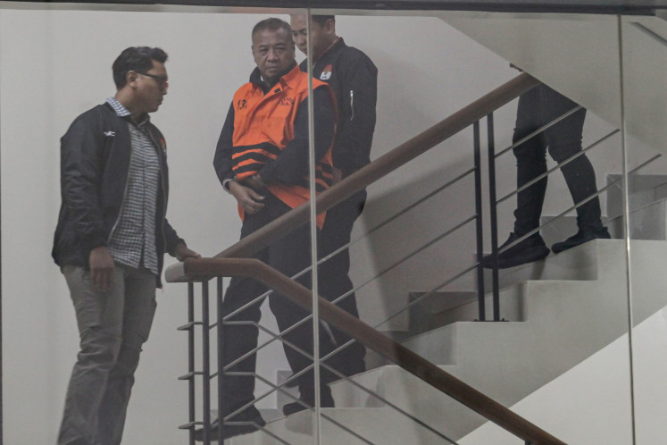 Tulungagung Regent Gatut Sunu Wibowo (second left), in a detainee vest, is escorted by Corruption Eradication Commission (KPK) officers on April 12, 2026, after he was interrogated in relation to extortion charges at the KPK headquarters in Setiabudi, South Jakarta.