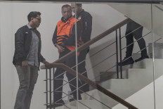 Tulungagung Regent Gatut Sunu Wibowo (second left), in a detainee vest, is escorted by Corruption Eradication Commission (KPK) officers on April 12, 2026, after he was interrogated in relation to extortion charges at the KPK headquarters in Setiabudi, South Jakarta.
