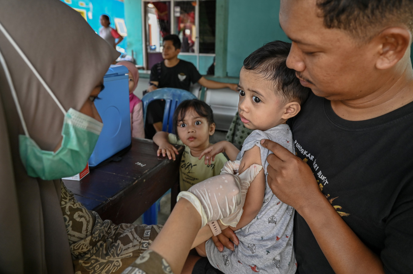 A healthcare worker from the Nosarara community health center (Puskesmas) administers a measles vaccine to a child at the Melati integrated health services post (Posyandu) in Palupi village, Palu, Central Sulawesi, on April 2, 2026.