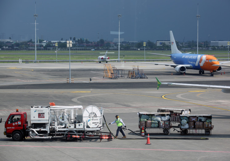  A worker pulls a hose after refueling a commercial aircraft with aviation fuel on April 7, 2026, at Terminal 1C of Soekarno-Hatta International Airport in Tangerang, Banten.