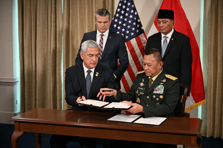 US Defense Secretary Pete Hegseth (Top-left) and Indonesian Defense Minister Sjafrie Sjamsoeddin (Top-R) look on as US Air Force Major General Kelly McKeague (left), and Major General Agus Widodo (right), sign a memorandum of understanding at the Pentagon in Washington, DC, on April 13, 2026. 
