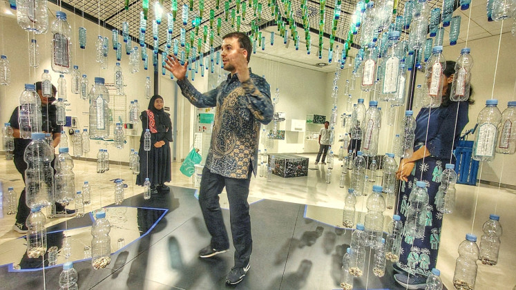 Waste lessons: At a house-like installation made of wire mesh and plastic bottles suspended on threads, Noud Sleumer explains the importance of separating waste at home during the exhibition on Feb. 5, 2026, where it can have the greatest impact across the system.