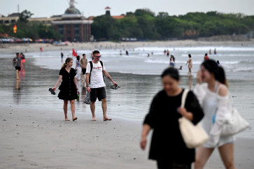 Beachgoers walk the sandy shores of Kuta, just south of Bali&rsquo;s provincial capital Denpasar, on April 8, 2026.