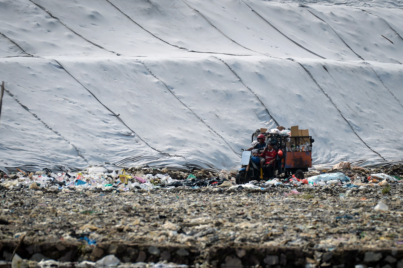 Endless waste crisis: A worker rides a garbage transport motorbike on April 14 at the Jatiwaringin landfill in Tangerang regency, Banten. The Environment Ministry has urged regional governments to immediately address open dumping practices at landfills and transition to a controlled landfill system, in which waste is covered with layers of soil periodically, with a deadline set for July 2026 to minimize environmental pollution and disaster risks.