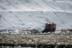 Endless waste crisis: A worker rides a garbage transport motorbike on April 14 at the Jatiwaringin landfill in Tangerang regency, Banten. The Environment Ministry has urged regional governments to immediately address open dumping practices at landfills and transition to a controlled landfill system, in which waste is covered with layers of soil periodically, with a deadline set for July 2026 to minimize environmental pollution and disaster risks.