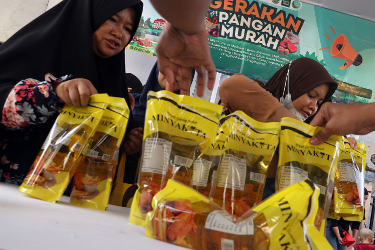 Residents purchase Minyakita cooking oil during a low-cost food program in Cisalak, Depok, West Java, Indonesia, Tuesday, April 7, 2026. The Depok city government, in cooperation with Bulog, organized the event, offering various staple foods below market prices to help stabilize supply and prices and ease the burden on residents.