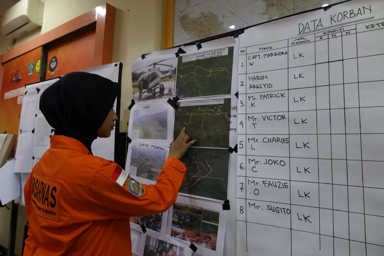 A search and rescue (SAR) team member reviews data on the Airbus Helicopter H130 crash on Thursday in Sungai Raya, Kubu Raya regency, West Kalimantan. A joint SAR team stepped up evacuation efforts after the helicopter lost contact and was later confirmed to have crashed in a forest in Nanga Taman, Sekadau regency, earlier that morning. 
