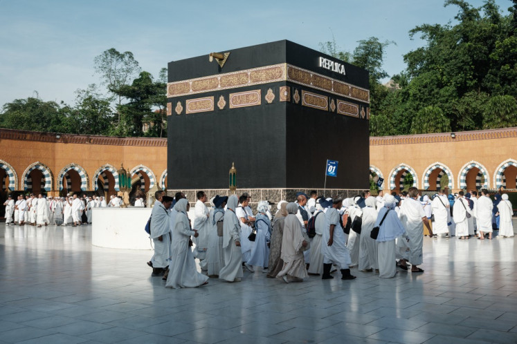 Prospective Indonesian pilgrims practice circumambulation rituals around a replica of the Kaaba, during a training session at the Al Mahmudah Manasik Training Center (AMTC) in South Tangerang on April 5, 2026. The centre provides a simulated experience of Mecca's pilgrimage sites ahead of the Haj season in late May.