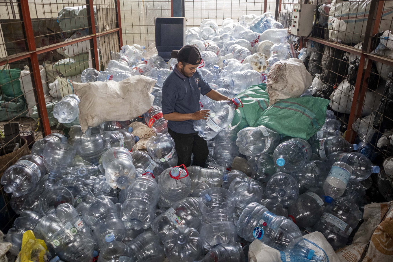A worker sorts used plastic water bottles on April 17, 2026, at the Samici main waste bank in Cimahi, West Java. 