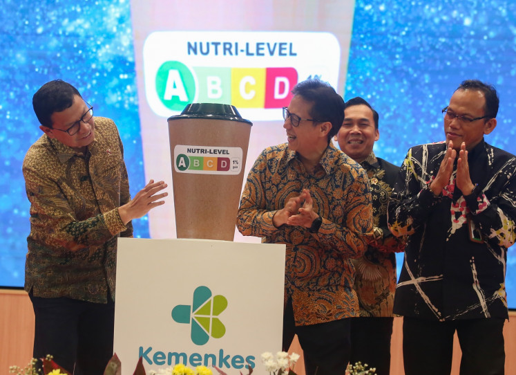 BPOM chief Taruna Ikrar (left) and Health Minister Budi Gunadi Sadikin (second right) look at an example of a Nutri-Level label during the launch event on April 14 in Jakarta.