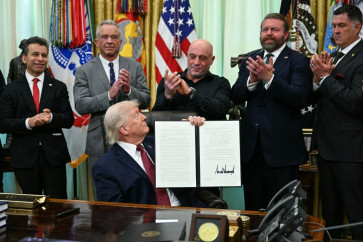 FDA Commissioner Marty Makary (from left to right), Health and Human Services Secretary Robert F. Kennedy Jr., US media personality Joe Rogan, W. Bryan Hubbard, CEO of Americans for Ibogaine, and former Navy SEAL Marcus Luttrell applaud after US President Donald Trump signed an executive order in the Oval Office of the White House in Washington, DC on April 18, 2026. The executive order aims to further US federal medical research and clinical trials for certain psychedelic drugs.