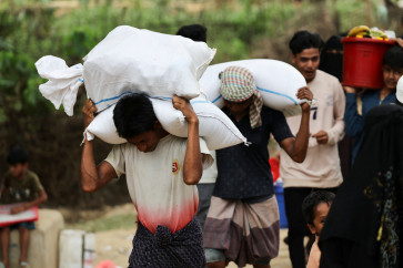 Rohingya refugees carry rice sacks that they receive as ration from the World Food Program (WFP), at a refugee camp in Cox's Bazar, Bangladesh, April 18, 2026.