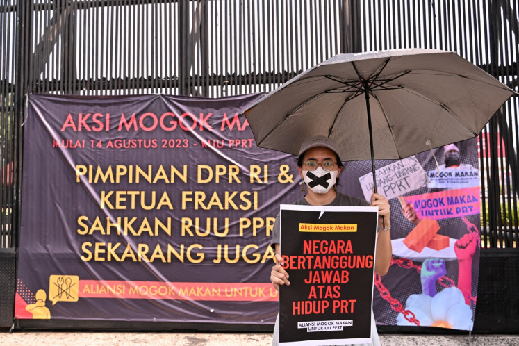 An activist takes part in a hunger strike outside the Senayan legislative complex in Jakarta on Aug. 14, 2023, as part of a protest requesting lawmakers pass the long-awaited bill to protect domestic workers.