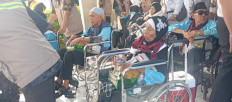 Haj officials usher elderly haj pilgrims on wheelchairs for their departure for Medina, Saudi Arabia, at Batam Haj Dormitory in Batam, Riau Islands, on April 22, 2026. Batam sent the first haj flight group on April 22, 2026, consisting of 445 pilgrims.   