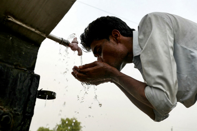 A supporter drinks water from a pipe at the end of the Kisan Samman Sammelan (farmer's honor conference) addressed by Indian Prime Minister Narendra Modi on the outskirts of Varanasi, India on June 18, 2024 amid heatwave.