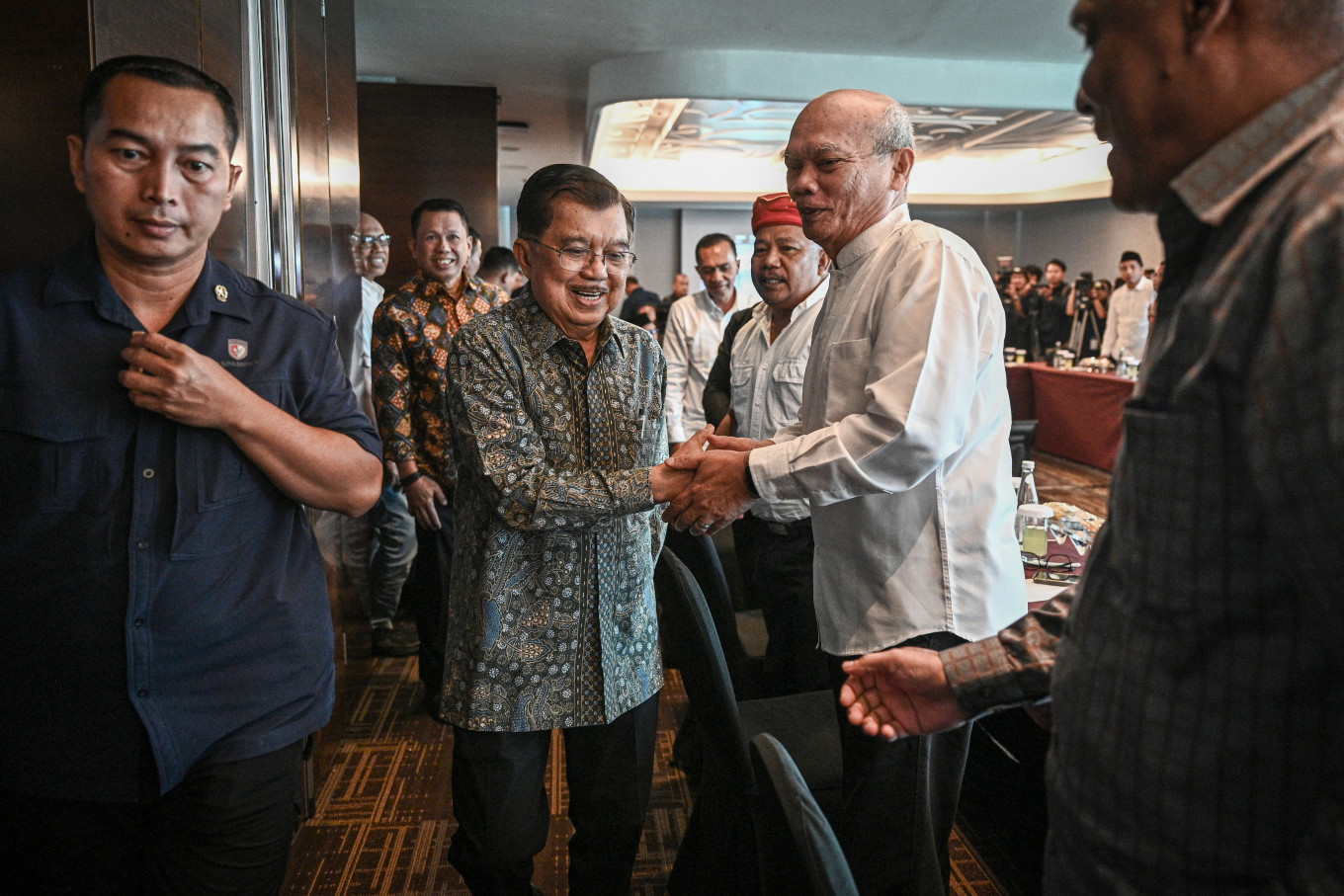 Former vice president Jusuf Kalla (center) shakes hands with Christian delegate from the Malino I peace talks, Rinaldi Damanik (right) on Tuesday during a meeting with figures involved in the Malino I peace process for Poso and Malino II for Maluku in Jakarta. The meeting was held in an effort to ease tensions following a viral video clip of Kalla&rsquo;s lecture at Gadjah Mada University (UGM), which was accused of blasphemy and led to police reports.