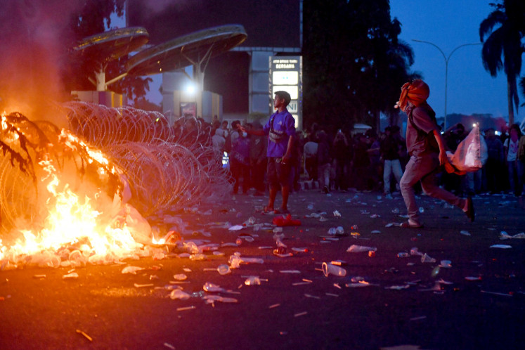 Protesters throw sacks at police on Tuesday during a demonstration outside the East Kalimantan governor&rsquo;s office in Samarinda. The rally, which called for a full audit of provincial government activities and an end to corruption, collusion and nepotism, turned chaotic.