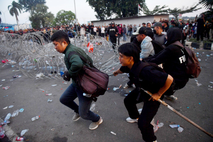 Street aspirations: Protesters pull barbed wire during a demonstration on April 21 in front of the East Kalimantan governor&rsquo;s office in Samarinda, East Kalimantan.