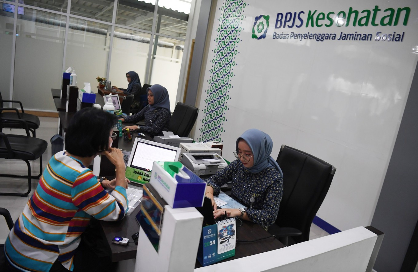 A Health Care and Social Security Agency (BPJS Kesehatan) official helps a customer on May 14, 2024, at the agency's South Jakarta office. 