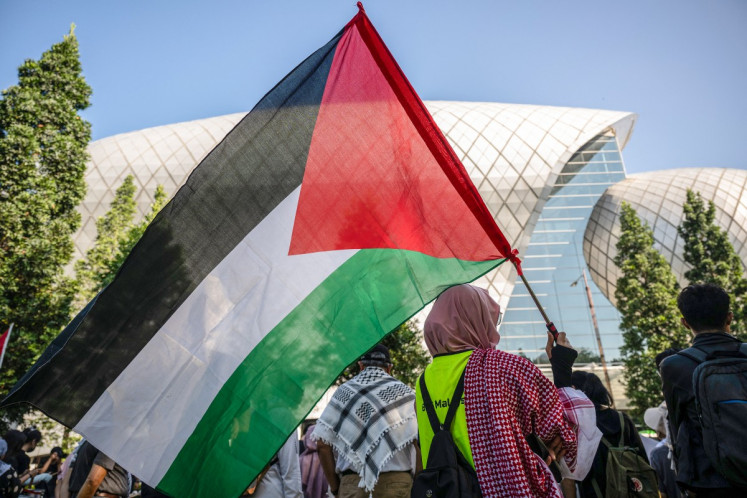 A protester carries a Palestinian flag during a rally condemning United States-Israeli attacks on Iran and Israeli attacks on Lebanon and Palestine on the sidelines of the Defence Services Asia (DSA) Exhibition and Conference outside the Malaysia International Trade and Exhibition Centre (MITEC) in Kuala Lumpur, Malaysia on April 20, 2026. 