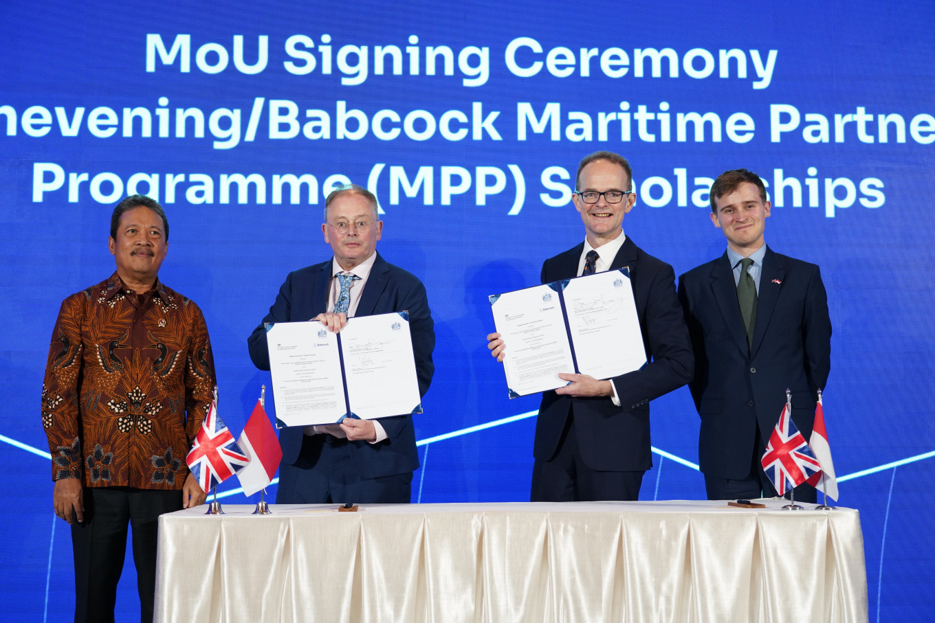 Babcock International Group chief executive officer David Lockwood (second left) and United Kingdom Ambassador to Jakarta Dominic Jermey (second right) display Memorandum of Understanding documents on April 23, flanked by Indonesian Maritime Affairs and Fishery Minister Sakti Wahyu Trenggono (left) and UK Aviation, Maritime and Decarbonization Minister Keir Mather in Jakarta. The MoU provides Babcock/Chevening Scholarships for 30 recipients in three years, as part of the UK-Indonesia Maritime Partnership Program which was launched during the event.