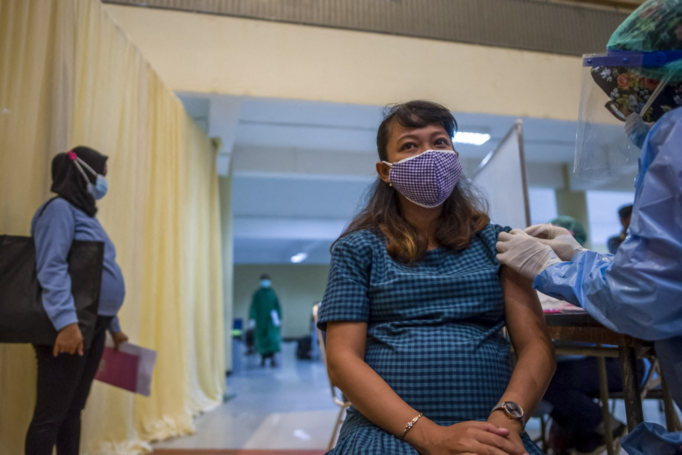 A pregnant woman receives the Sinovac COVID-19 vaccine on Aug. 19, 2021, in Surabaya, East Java, during an accelerated vaccination program including pregnant women.