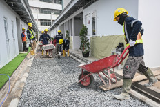 Workers pave a walkway to a housing project with pebbles on April 23 in Senen, Jakarta. The Public Housing and Settlements Ministry will build 324 housing units with public bathrooms, 'musholla' (prayer rooms) and kitchens for squatters who lived along the railway track in the area.