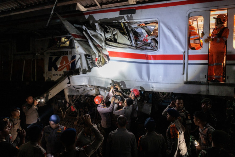 Rescuers work at the site where a passenger train locomotive pierced through the rear carriage of a commuter train at Bekasi Timur Station in Bekasi, West Java, on April 28, 2026. Two trains collided late on April 27, 2026, the state-owned rail company KAI said, killing at least seven people and prompting a mass evacuation effort.