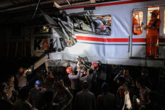 Rescuers work at the site where a passenger train locomotive pierced through the rear carriage of a commuter train at Bekasi Timur Station in Bekasi, West Java, on April 28, 2026. Two trains collided late on April 27, 2026, the state-owned rail company KAI said, killing at least seven people and prompting a mass evacuation effort.