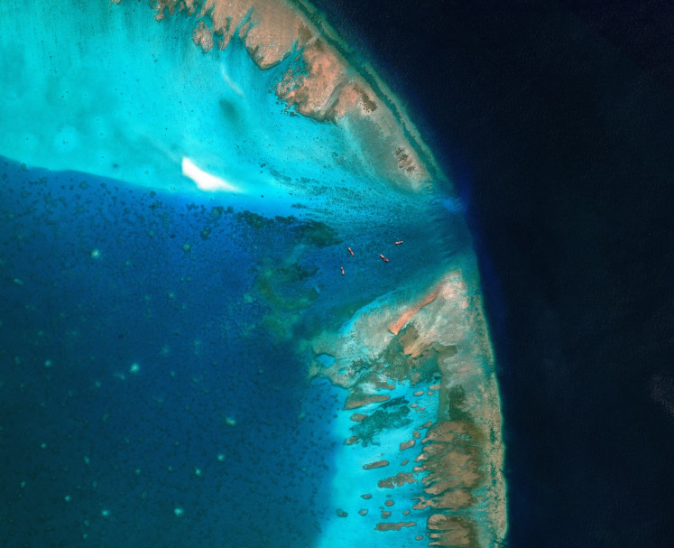 A satellite image shows fishing vessels blocked by a floating barrier at the entrance to the disputed Scarborough Shoal, in this file photo taken in the South China Sea on April 11, 2026.