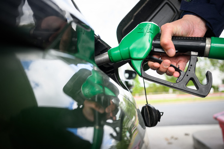 A man fills in his car at a gas station in Saint-Etienne-de-Montluc, western France, on April 15, 2026, as the US-Israel war on Iran, launched on Feb. 28, has roiled global energy and equities markets, sending oil prices skyrocketing after Tehran virtually closed the key Strait of Hormuz.