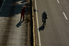 A Public Facilities and Infrastructure Handling (PPSU) worker cleans the street on April 19 during the Car Free Day event at Jl. Jenderal Sudirman in South Jakarta.