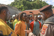 A police officer speaks with protesters opposing violence in Papua on April 27 in Jayapura, Papua. Jayapura Police deployed 1,200 joint personnel from the police and military to secure the protest. 