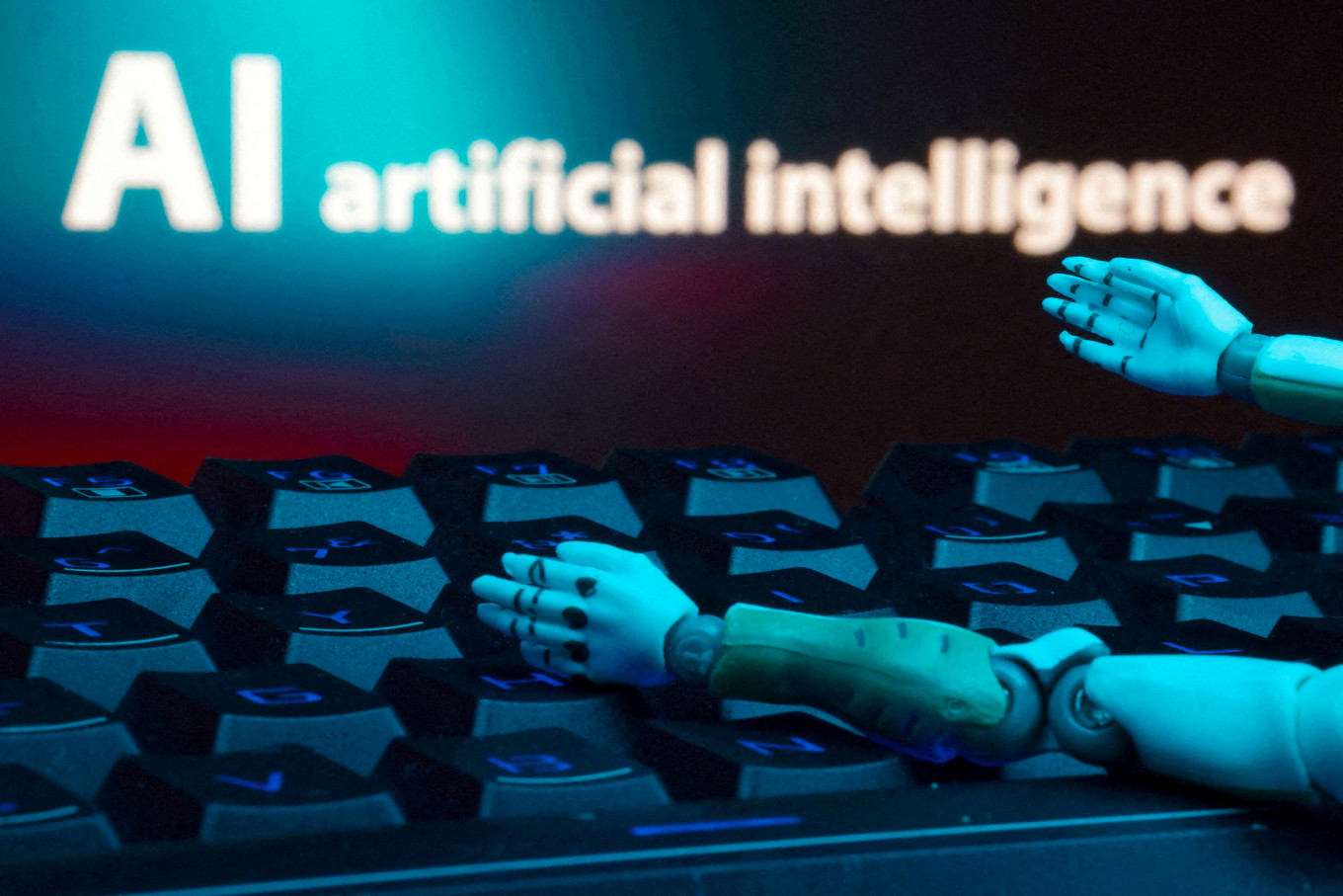 A message reading &ldquo;AI artificial intelligence,&ldquo; a keyboard and robot hands are seen in this illustration created on Jan. 27, 2025.